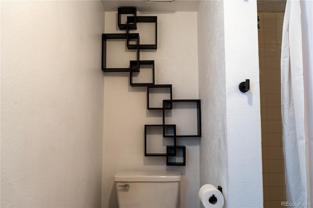 bathroom featuring a shower with curtain and toilet