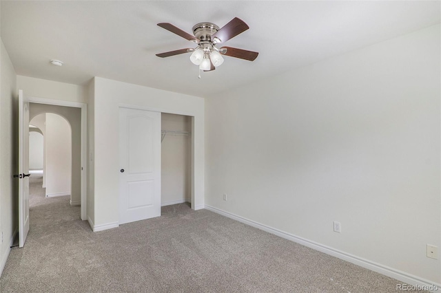 unfurnished bedroom featuring light carpet, a closet, and ceiling fan