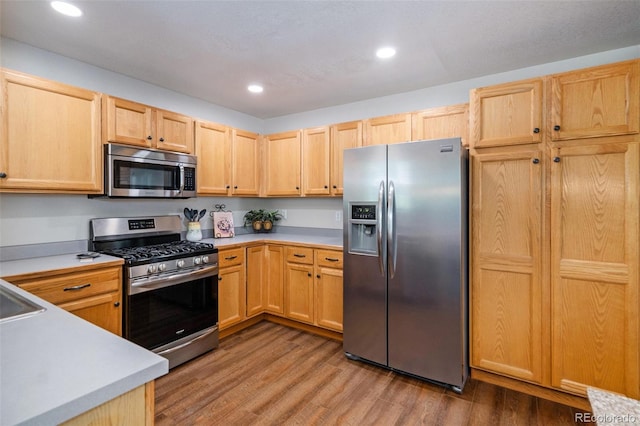 735 Poppy Pl, Highlands Ranch, CO 80129 - kitchen featuring appliances with stainless steel finishes, light brown cabinets, light countertops, wood finished floors, and recessed lighting