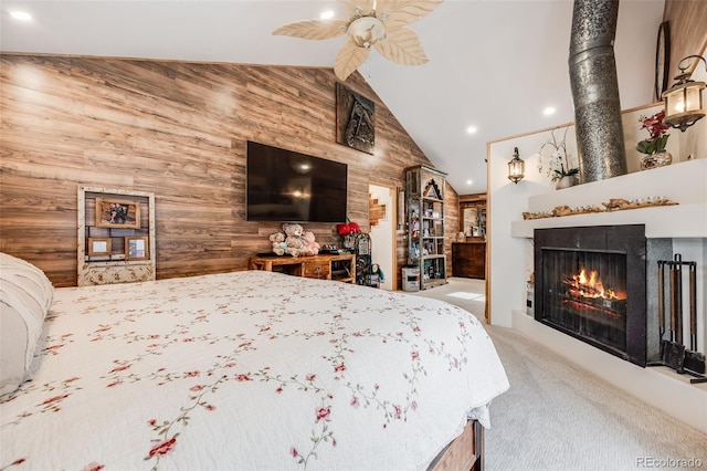 carpeted bedroom with a fireplace, wooden walls, and high vaulted ceiling