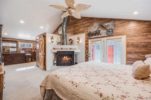 bedroom with french doors, lofted ceiling, light carpet, wooden walls, and access to exterior