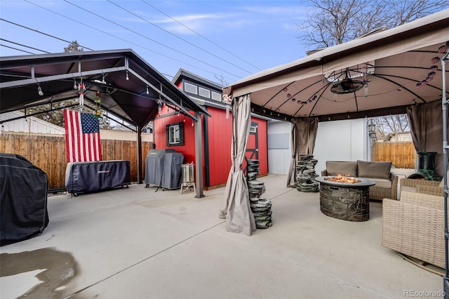 view of patio with a gazebo, an outdoor structure, area for grilling, and a fire pit