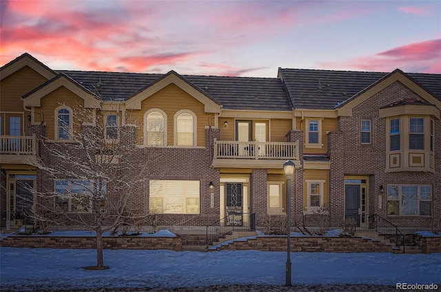 townhome / multi-family property with brick siding and a balcony