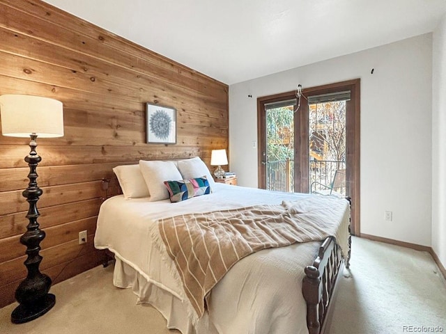 bedroom with light carpet, access to outside, baseboards, and wooden walls