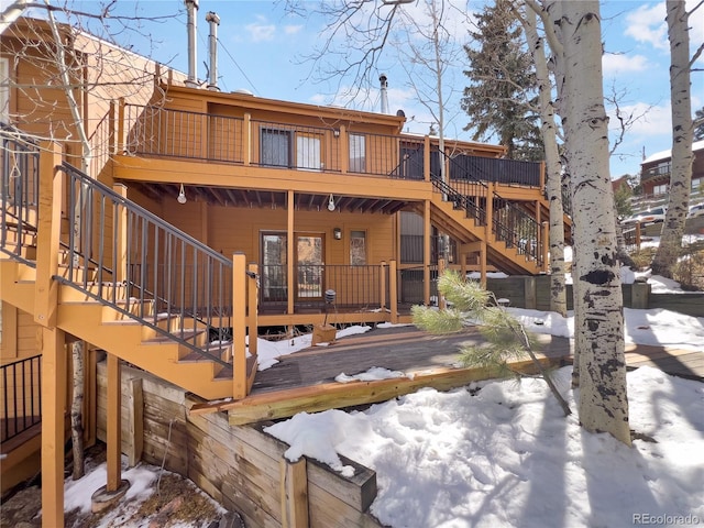 snow covered property with stairs