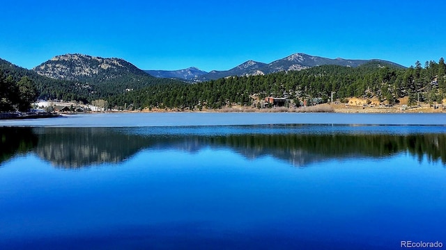 view of water feature with a mountain view and a wooded view