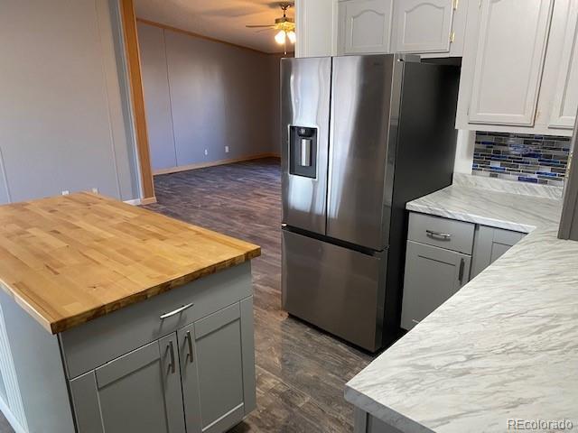 15758 Deerfield St, Sterling, CO 80751 - kitchen featuring tasteful backsplash, butcher block counters, stainless steel refrigerator with ice dispenser, and gray cabinetry