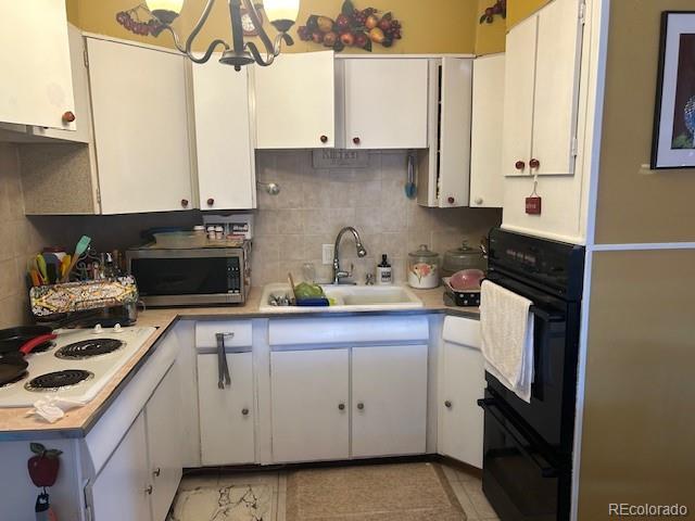 kitchen featuring white cabinets, white gas stovetop, oven, and sink