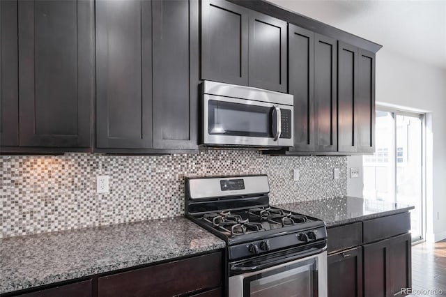 3063 Denver Dr, Fort Collins, CO 80525 - kitchen featuring dark stone countertops, backsplash, hardwood / wood-style floors, and appliances with stainless steel finishes