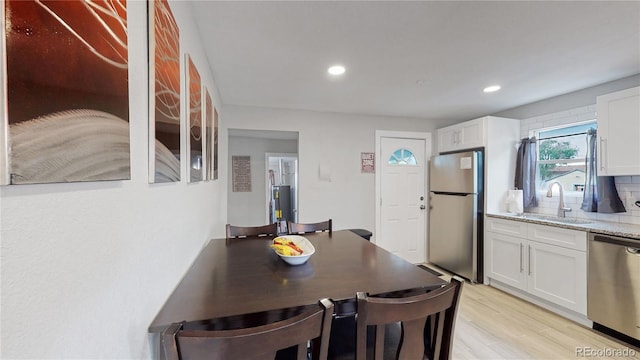 dining space with light hardwood / wood-style flooring and sink