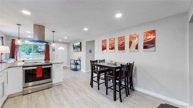 kitchen featuring stainless steel electric stove, decorative light fixtures, island range hood, and white cabinets