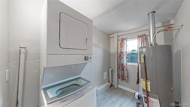 clothes washing area featuring hardwood / wood-style floors, a textured ceiling, gas water heater, and stacked washer and clothes dryer