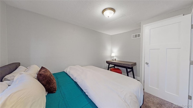 bedroom featuring carpet floors and a textured ceiling