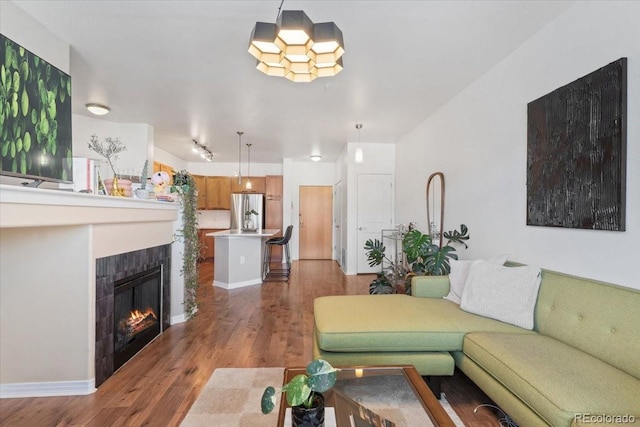 living room featuring a tiled fireplace and dark hardwood / wood-style floors