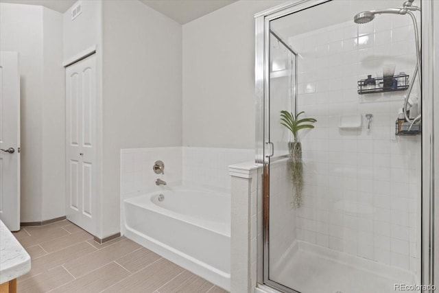 bathroom with shower with separate bathtub and tile patterned floors