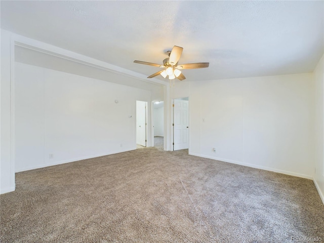 carpeted spare room with a ceiling fan