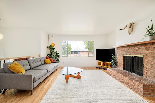 12193 W New Mexico Pl, Lakewood, CO 80228 - living room with light wood finished floors, a brick fireplace, and baseboards