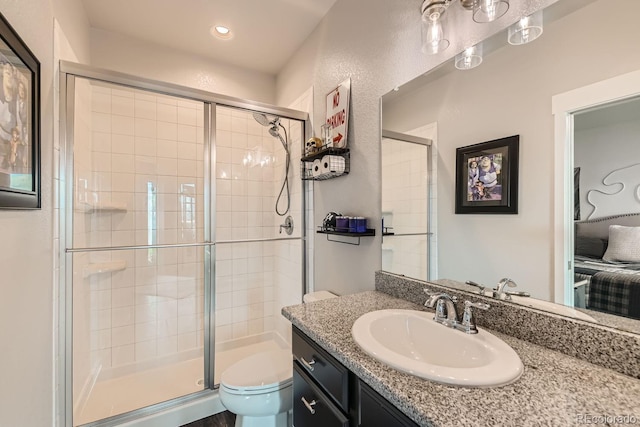 bathroom featuring an enclosed shower, vanity, and toilet