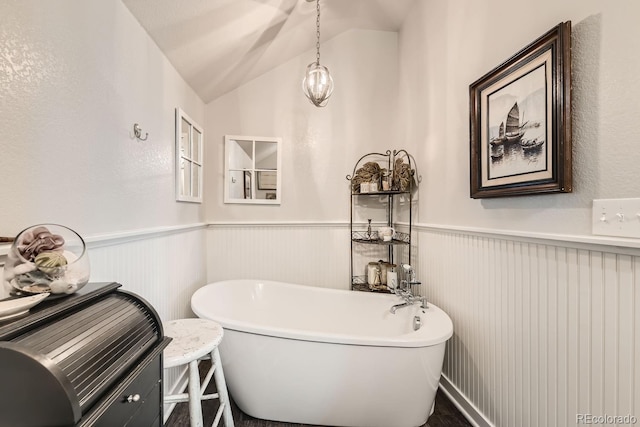 bathroom featuring a bath and lofted ceiling