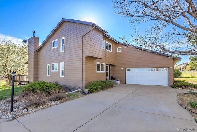 view of side of home featuring an attached garage, a chimney, and concrete driveway