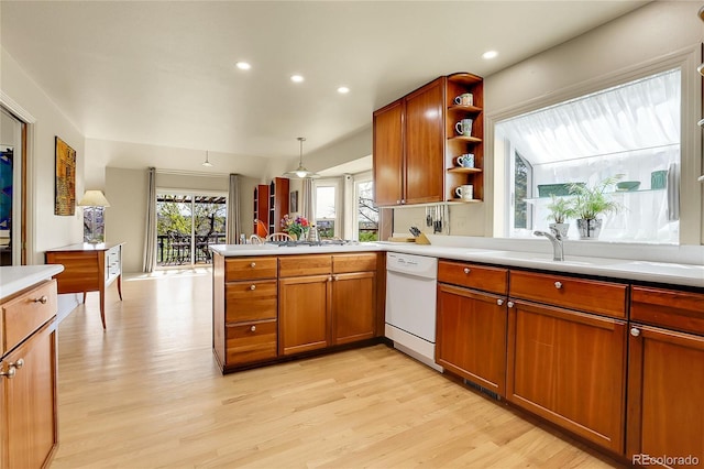 kitchen featuring white dishwasher, light countertops, light wood-style flooring, and open shelves