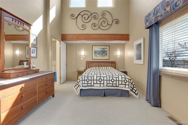 carpeted bedroom with beamed ceiling, a towering ceiling, and baseboards