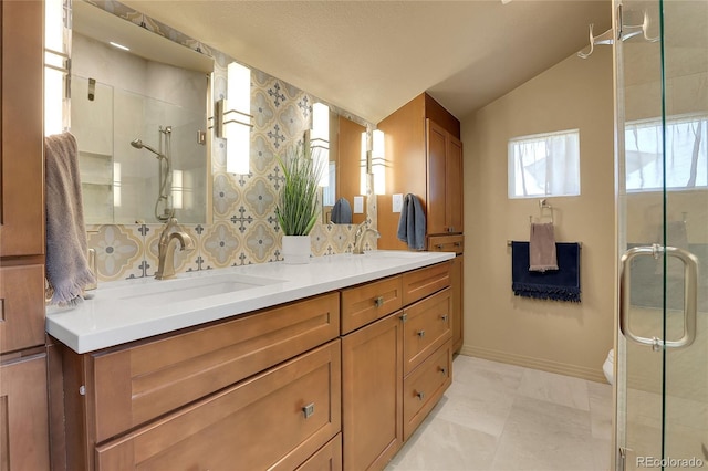 bathroom with lofted ceiling, a sink, double vanity, and a stall shower