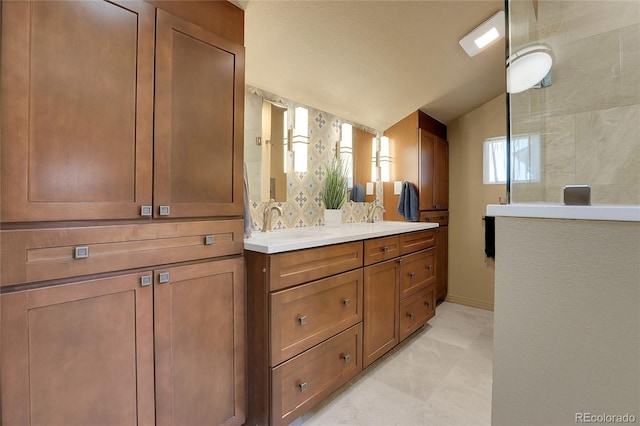 full bathroom with lofted ceiling, a sink, double vanity, and a tile shower