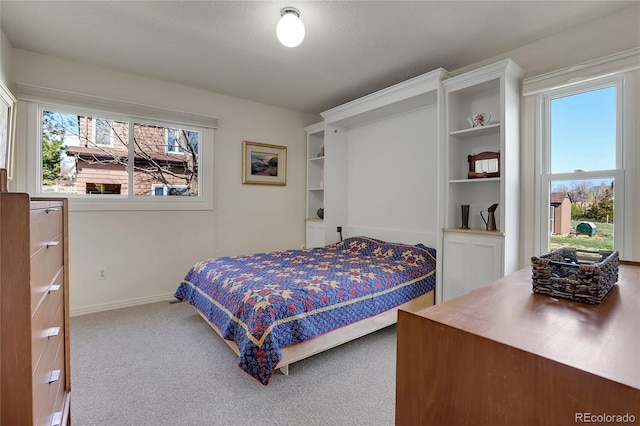 carpeted bedroom featuring baseboards and multiple windows