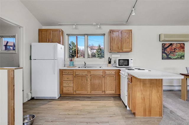 kitchen with a wall mounted air conditioner, rail lighting, a peninsula, and white appliances