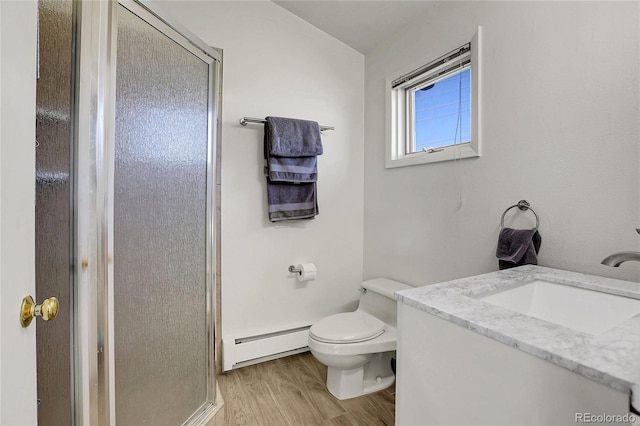 full bathroom with a shower stall, wood finished floors, toilet, vanity, and baseboard heating