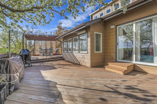 wooden deck with a pergola and area for grilling