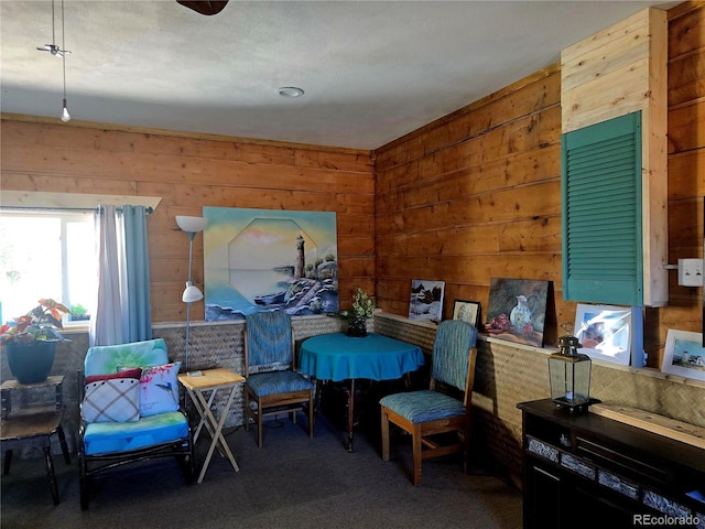 carpeted bedroom featuring wooden walls