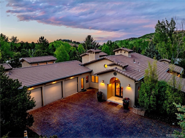 5904 Meadowbrook Dr, Morrison, CO 80465 - mediterranean / spanish house with a tiled roof, a garage, stucco siding, and driveway