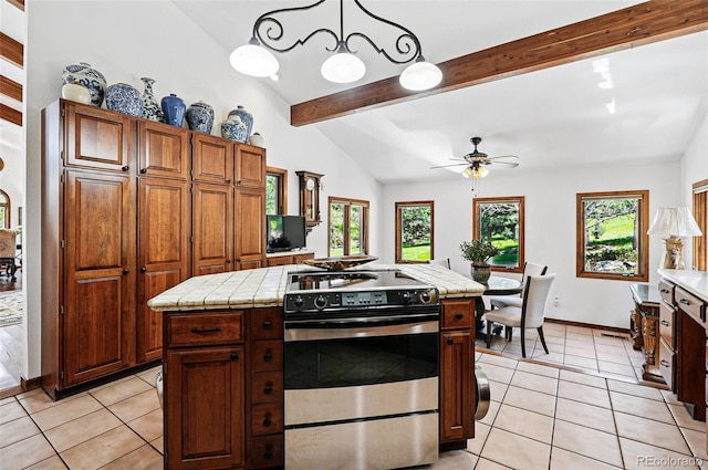 5904 Meadowbrook Dr, Morrison, CO 80465 - kitchen featuring stainless steel range, light tile patterned floors, tile counters, a ceiling fan, and a center island