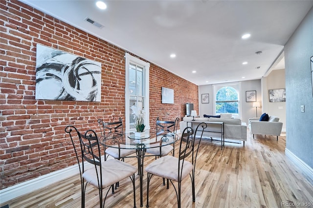 dining room featuring brick wall, visible vents, wood finished floors, and recessed lighting