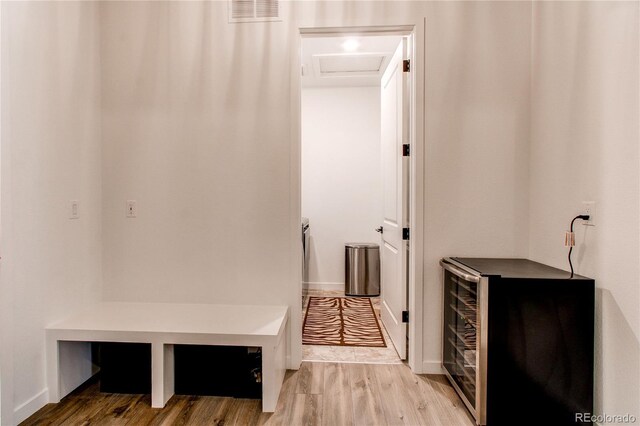 mudroom with wood finished floors and attic access