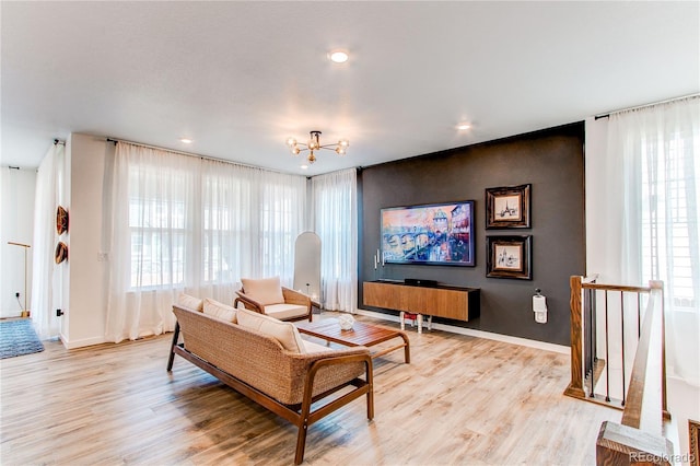 living area featuring light wood-style floors, baseboards, a chandelier, and recessed lighting