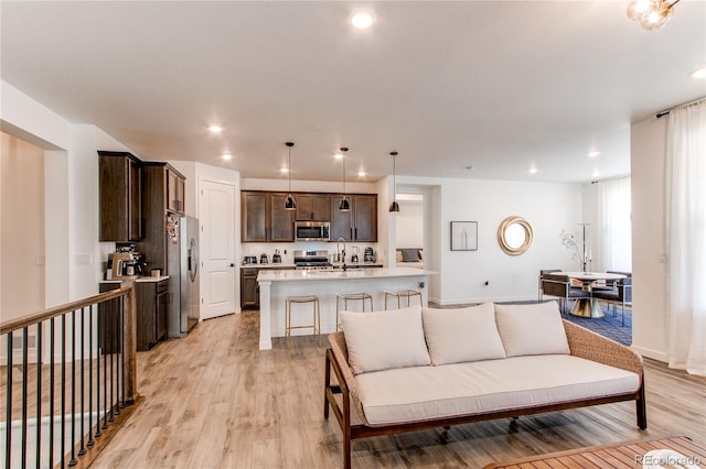 living area featuring light wood-style floors, recessed lighting, and baseboards