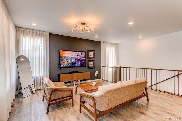living area with a chandelier, plenty of natural light, wood finished floors, and recessed lighting