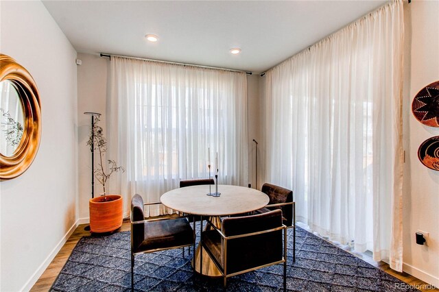 dining area featuring wood finished floors, baseboards, and recessed lighting