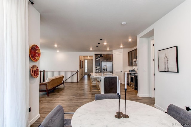 dining room with dark wood finished floors, baseboards, and recessed lighting