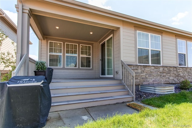 entrance to property with stone siding and covered porch