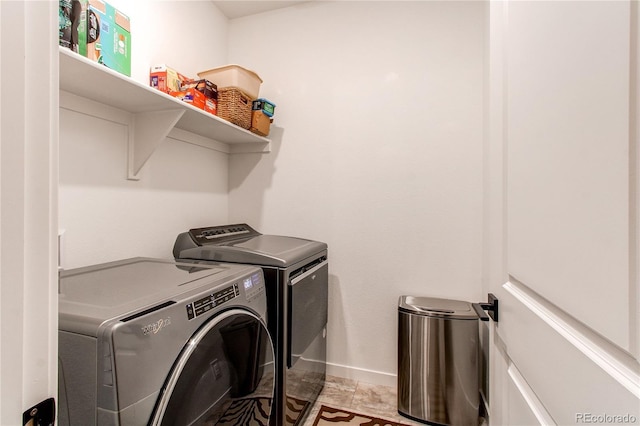 washroom featuring washing machine and dryer and baseboards