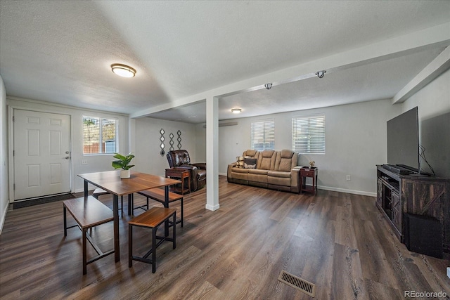 dining room with a textured ceiling and dark hardwood / wood-style flooring