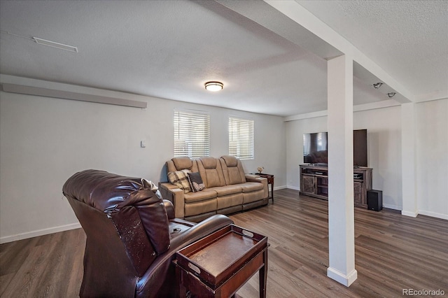 living room featuring dark wood-type flooring and a textured ceiling