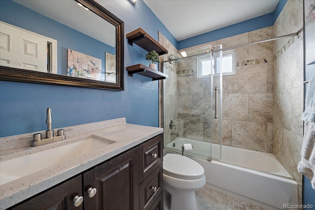 full bathroom with toilet, vanity, and bath / shower combo with glass door