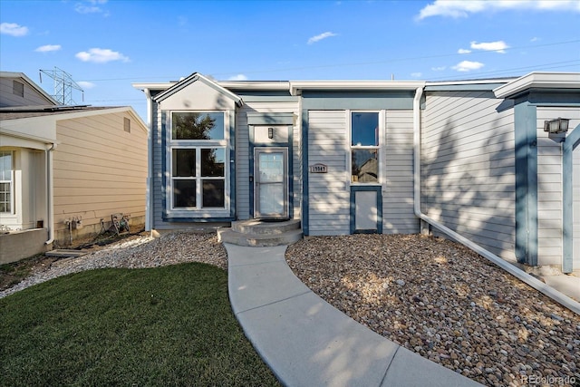 property entrance with a lawn