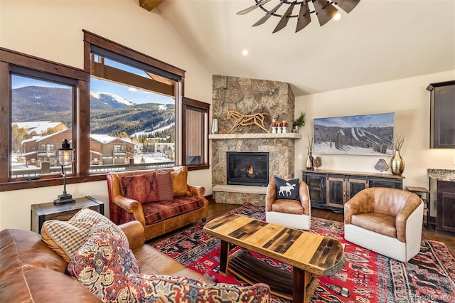 living room with vaulted ceiling with beams, wood-type flooring, and a stone fireplace