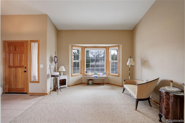 sitting room featuring light tile patterned floors, baseboards, and light colored carpet